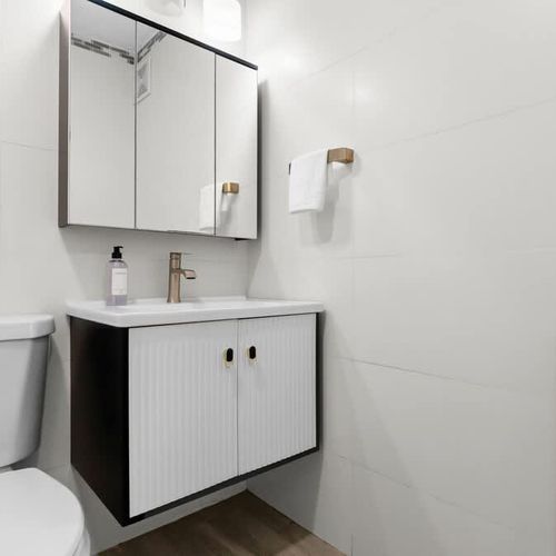 Step into our pristine and modern bathroom, featuring sleek design and high-end finishes. Enjoy ample counter space, stylish fixtures, and a bright, clean ambiance for your daily refresh.