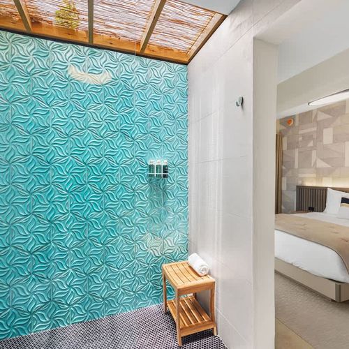 Cozy integrated living space featuring an inviting bed with plush bedding, efficient air conditioning for comfort, and an en-suite open-air shower bathed in natural light.