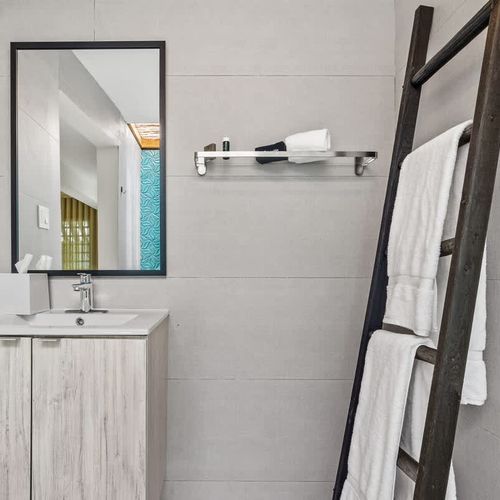 Unwind in this contemporary bathroom featuring a spacious vanity and plenty of natural light.