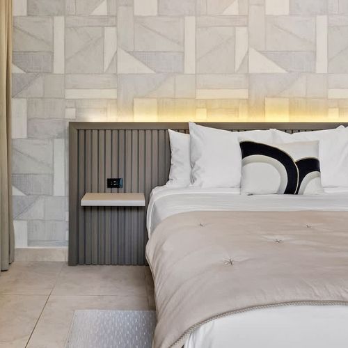 Elegant sleeping space boasting a sleek air conditioning unit for optimal comfort, complemented by tasteful decor and neutral tones.