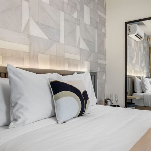 Cozy retreat with soft ambient lighting, highlighting unique geometric patterns on the wall, creating a warm and inviting atmosphere.