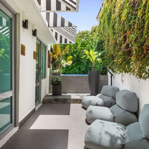 Step outside and embrace the vibrant energy of our boutique hotel. The sparkling pool, outdoor gym, and charming signage create a captivating atmosphere that invites you to explore and play