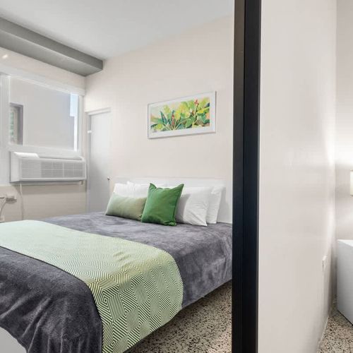 This well-appointed room offers both comfort and convenience, featuring a cozy bed and essential amenities nearby, ensuring a seamless and enjoyable stay.