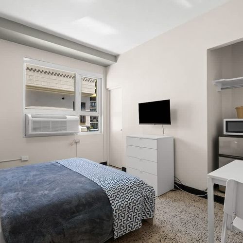 Fresh and functional! This modern bedroom boasts a comfortable queen bed with stylish bedding, providing a chic yet relaxing space for your stay.