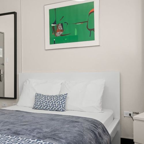 Luxury and comfort combined. This spacious bedroom features an opulent queen bed with extra pillows, inviting you to sink in and enjoy a truly relaxing experience.