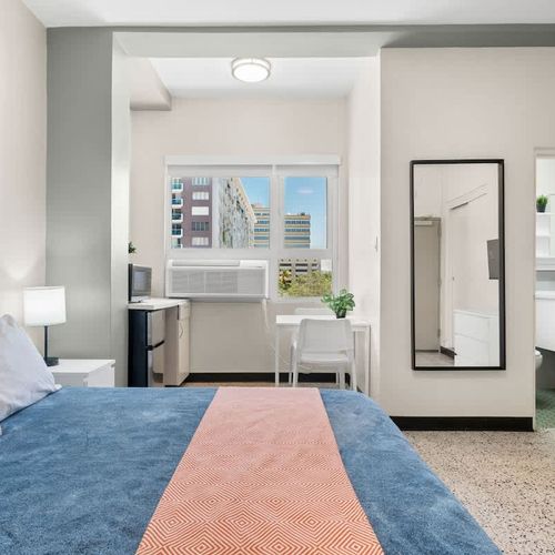 This well-appointed space combines comfort with convenience, offering a cozy bed, a small table for your essentials, and ample storage for your belongings.