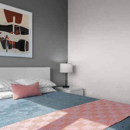 Discover a roomy and well-lit space, offering a comfortable bed and a full-length mirror, perfect for getting ready to explore or simply unwinding.