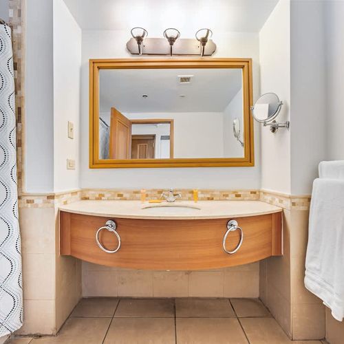 Modern elegance meets function in this bathroom, complete with a spacious vanity mirror.