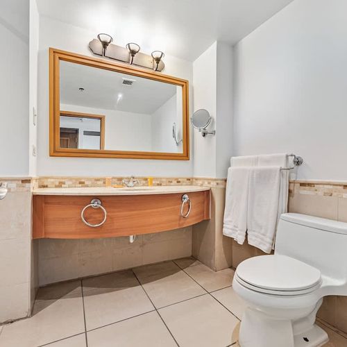 A stylish bathroom with a sleek vanity mirror, perfect for refreshing moments of self-care.