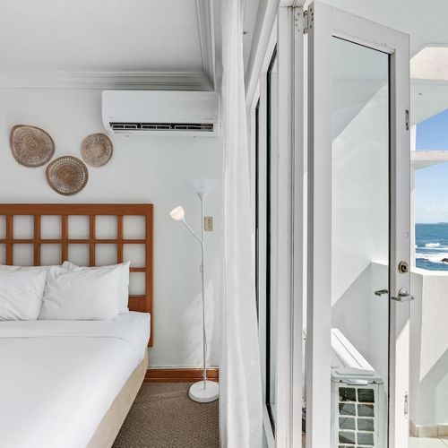 A serene bedroom that opens directly to a balcony, where the beach becomes your personal paradise.