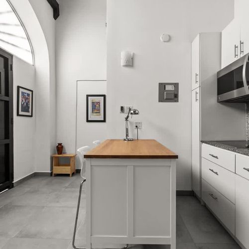 livingroom with kitchen , stainless steel fridge, air conditioner, sofabed, seats, ceiling fan, microwave,  reading lamps, cabinets