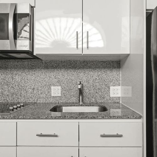 livingroom with kitchen , stainless steel fridge, air conditioner, sofabed, seats, ceiling fan, microwave,  reading lamps, cabinets