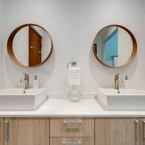A modern bathroom with two mirrors, great for couples or friends.