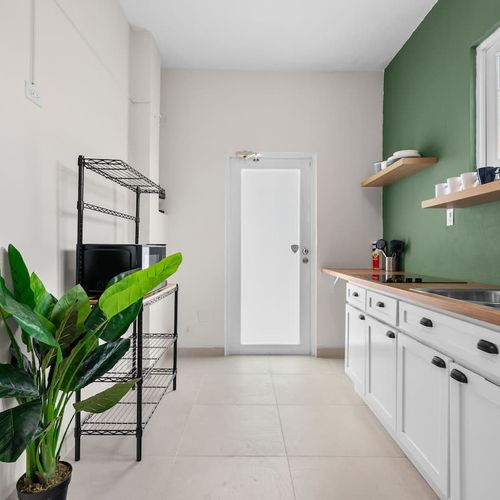 Modern, clean kitchen with open shelving and ample counter space.