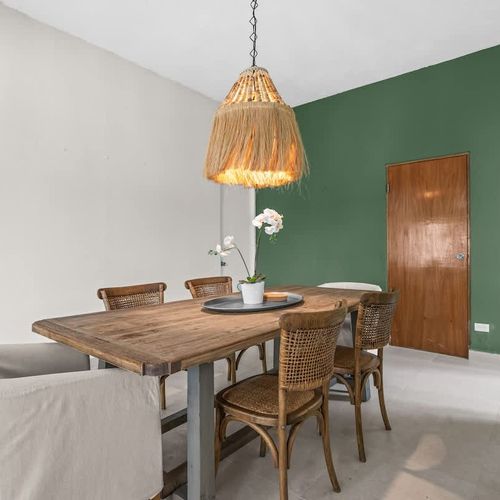 Dine in a cozy, stylish space with a calming green backdrop.