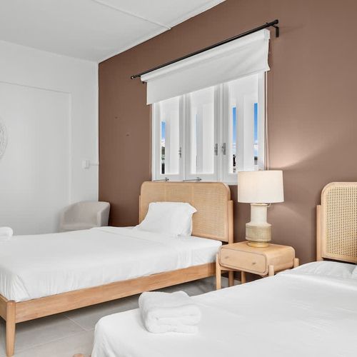 A comfortable bedroom with a plush bed and ample natural light.