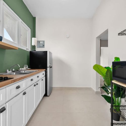 A pristine, fully equipped kitchen with a full-size refrigerator.