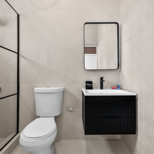 Clean, well-lit bathroom with a glass-enclosed shower.