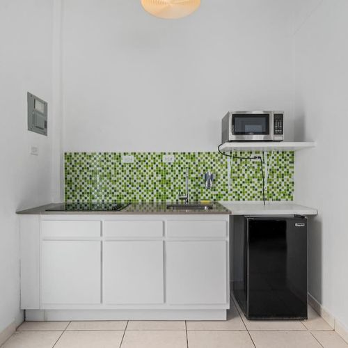 A clean, modern kitchenette with vibrant mosaic tiles. Perfect for a quick meal.
