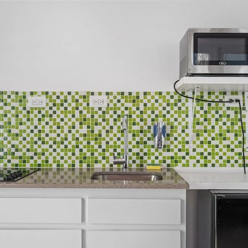 Prepare your favorite snacks in this well-equipped kitchen space with unique decorative tiles.