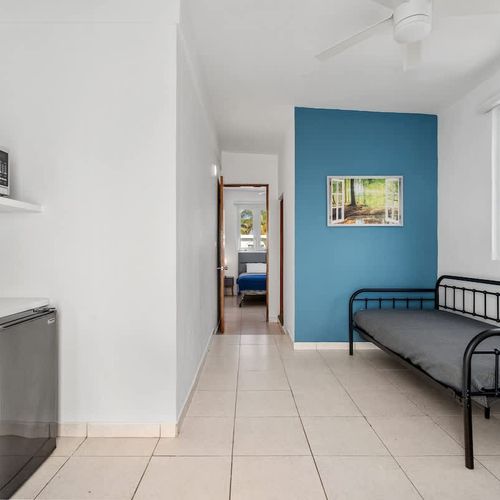 A well-lit common area with a TV and access to the bathroom. Simple and inviting.