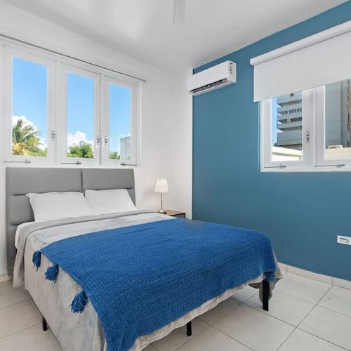 Relax in this tranquil bedroom. The soft blue wall creates a serene and inviting atmosphere.