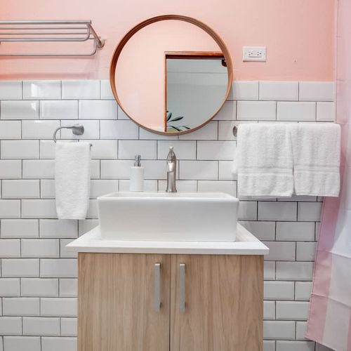 A clean and sleek bathroom with a large counter and a functional faucet.