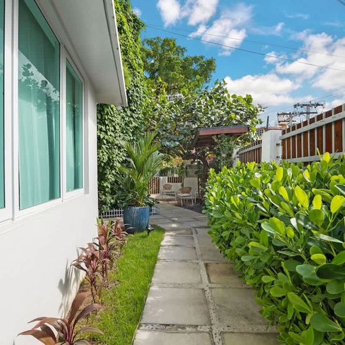 A tranquil walkway with lush plants and a cozy atmosphere.