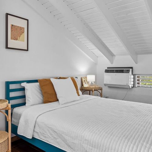 Unwind in a bright and airy bedroom featuring a plush bed, large window for natural light, and powerful AC – your perfect retreat after a day of exploring!