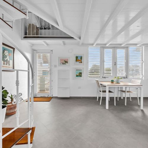 modern kitchen with stainless steel fridge and faucet, dining table and wall art and large windows