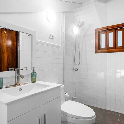 Freshen up in a sleek bathroom featuring a walk-in shower and full vanity.