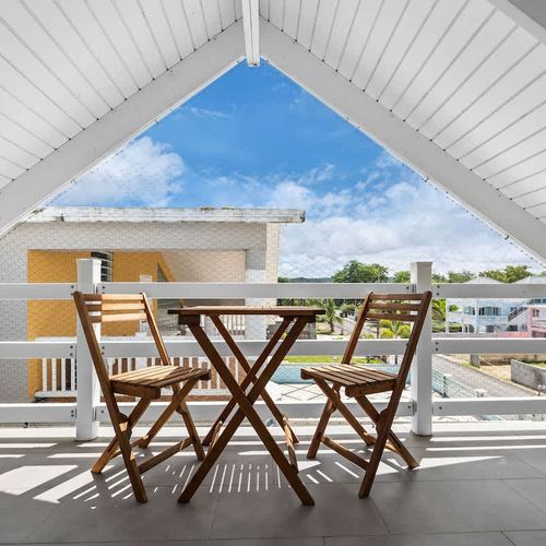 Perfect Balcony for Outdoor Dining. This balcony features a cozy table and chairs, creating an ideal setting for outdoor meals with a view.