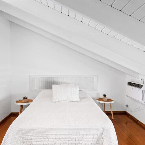 Unwind in a spotless white bedroom complete with comfy bed and cool air-conditioning for ultimate comfort.