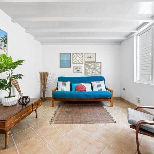 Sun-filled living room with a comfy couch and large windows – great for lounging and relaxing.