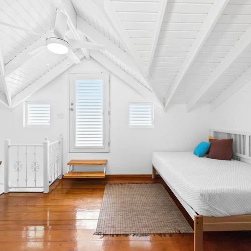 Cozy and clean bedroom with soft linens, air-conditioning, and serene white decor – your peaceful home base for a restful sleep.