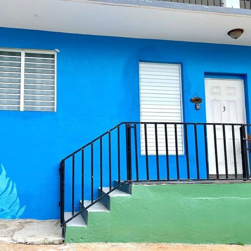 Step into serenity! Our private entrance, framed by a charming blue staircase, offers a welcoming and secure entry to your exclusive apartment.