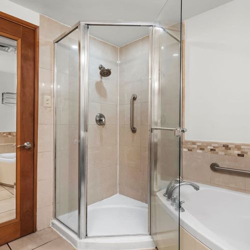 Refresh yourself in the spacious walk-in shower with clear glass doors, offering a clean and modern bathing experience