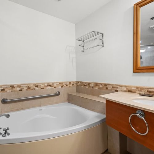 Our elegantly designed bathroom features a large vanity with ample counter space and a stylish basin, providing convenience for all your personal items.