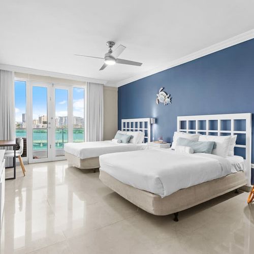 Wake up to stunning lagoon views from the comfort of two plush beds, perfect for a family or group of friends seeking a serene and spacious retreat.