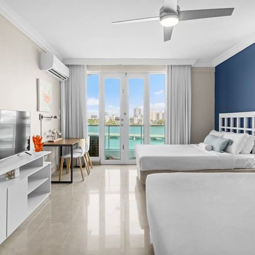 This vibrant and airy studio offers direct access to a private balcony overlooking the water, providing an idyllic setting for morning coffee or evening relaxation.