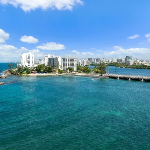 Marvel at the architectural beauty of the bridge stretching across the tranquil lagoon, connecting you to the bustling city beyond.