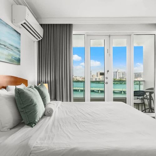 Your perfect escape: a cozy bed with a spectacular backdrop of the lagoon and city skyline.