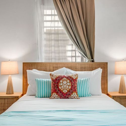 Spacious bedroom with a luxurious queen-size bed and plenty of natural light.