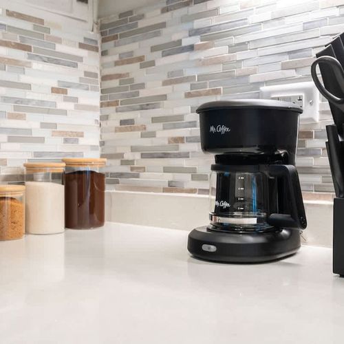 A clean modern kitchen with coffee maker and basic kitchen essentials.