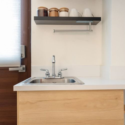 Imagine mornings here, brewing coffee and enjoying a quick breakfast before heading out to explore the vibrant neighborhood.  The clever layout maximizes space, providing ample counter area for meal prep while maintaining a chic, uncluttered aesthet