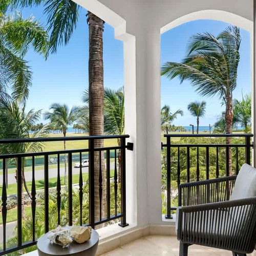 Unwind in tropical paradise on your private balcony. Enjoy breathtaking views of the ocean and lush palm trees while relaxing in stylish comfort.
