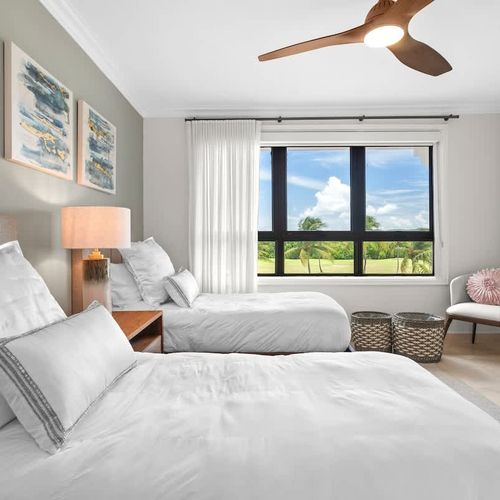 Twin Serenity: This inviting guest bedroom offers a peaceful retreat with twin beds dressed in crisp linens. The room features a calming neutral palette and ample natural light, creating a serene atmosphere. Enjoy stunning golf course views from the