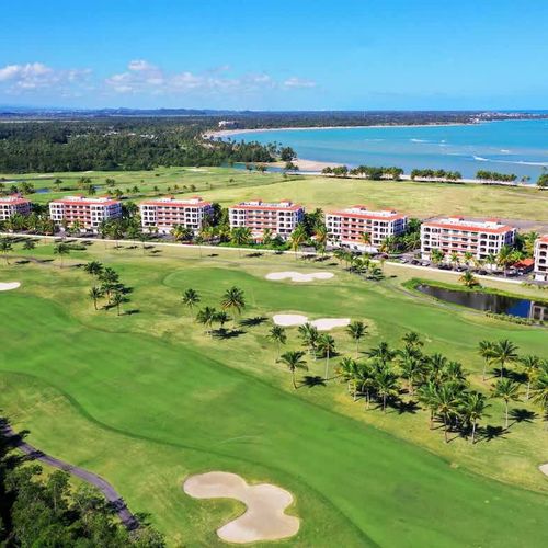 Discover paradise at the Country Club Residences at The Grand Reserve. This stunning aerial view showcases the resort's luxurious accommodations nestled amidst a championship golf course, offering breathtaking vistas of the ocean and lush tropical la