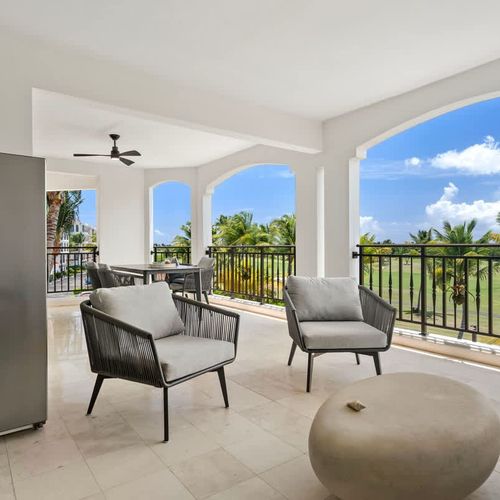 This spacious balcony is a perfect escape, with comfy seating, a stylish coffee table, and stunning views of the golf course and palm trees. The gentle breeze and natural sounds make it a serene spot to relax and enjoy the scenery.
