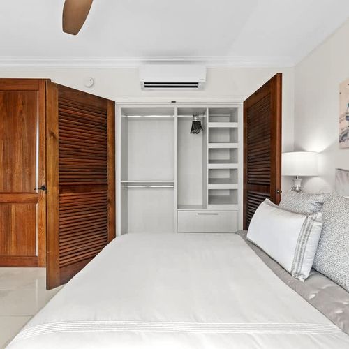 Serene and spacious bedroom with a king-sized bed. The room features ample closet space, a ceiling fan for comfort, and a tranquil atmosphere perfect for relaxation.